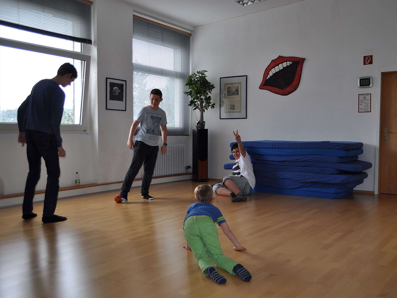 Eine Kindergruppe spielt Fußball in der Pause während der Stottertherapie